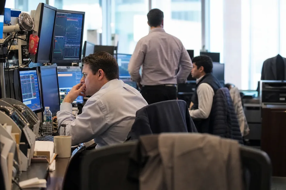 Analysts at their monitors on the trading floor of an investment firm